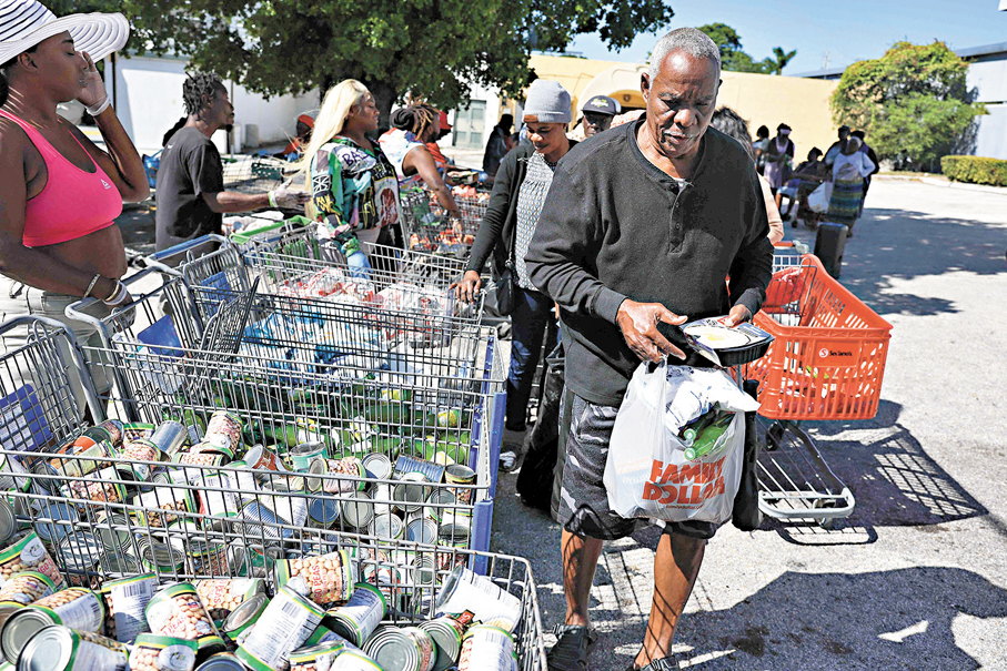 ●佛羅里達州低收入人士排隊領取食物。 法新社