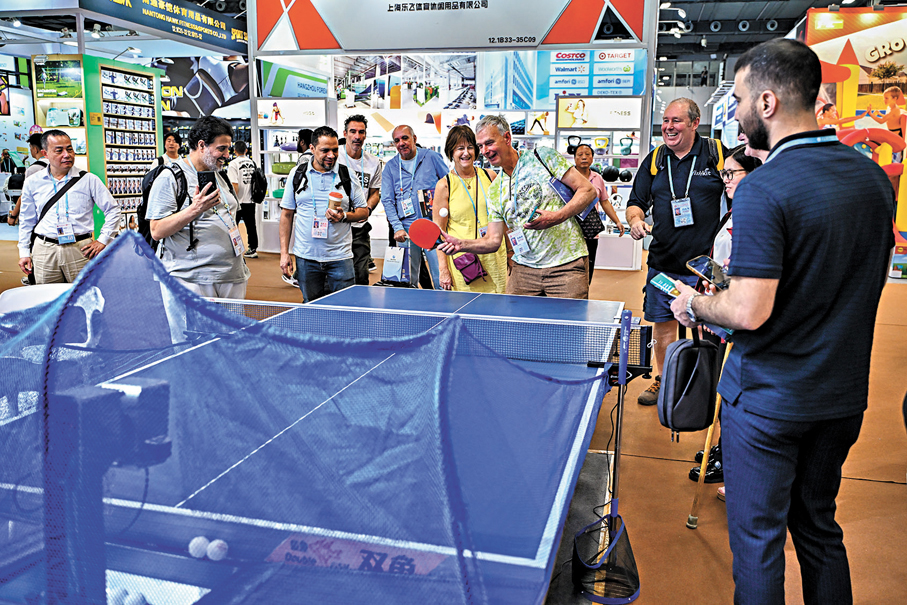 ●11月1日，境外採購商在廣交會上體驗中國企業展出的乒乓球智能發球機。 中新社