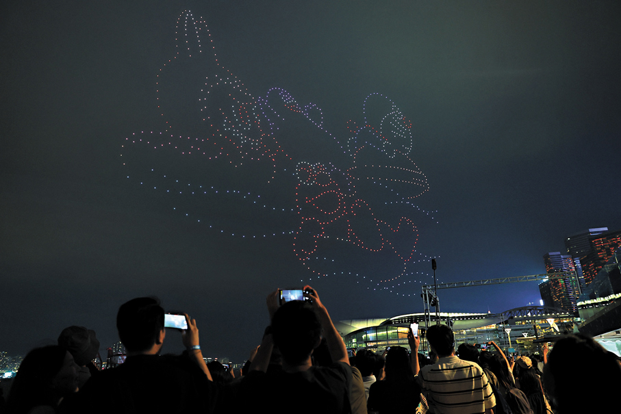 ●觀眾拍照記錄無人機表演。 香港文匯報記者萬霜靈  攝