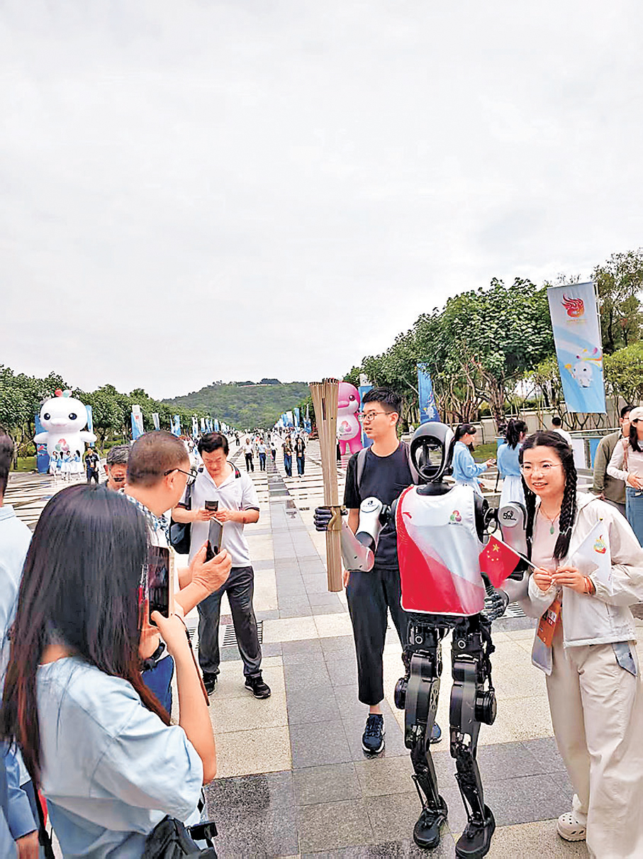 ●深圳市民爭相與火炬手、機器人「夸父」合影。 香港文匯報記者胡永愛  攝