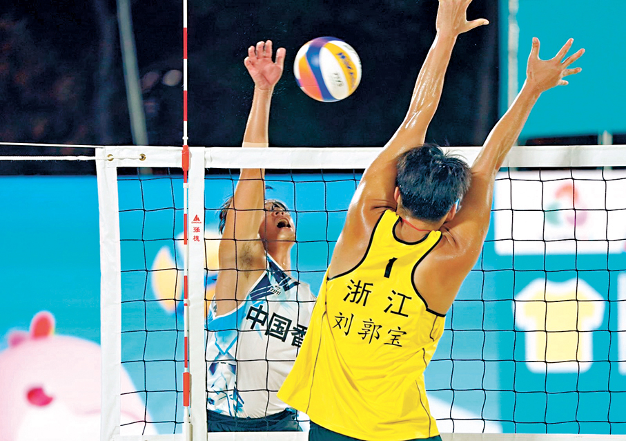 ●港隊黃嘉潤（左）無懼對手攔網扣球。 香港文匯報記者郭正謙  攝