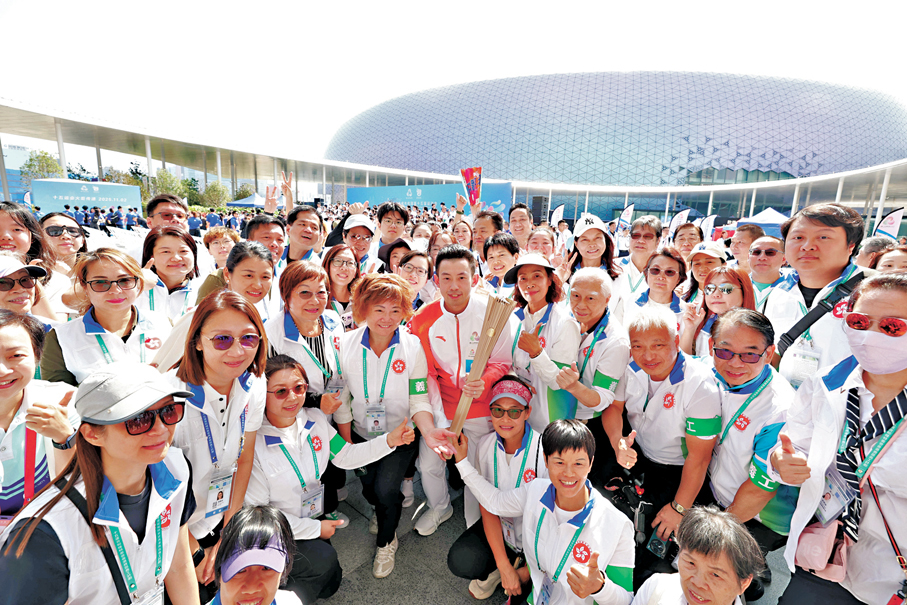 ●收火儀式於啟德體育園中央廣場舉行，乒乓球手黃鎮廷與一眾義工隊成員來一張大合照。香港文匯報記者曾興偉  攝