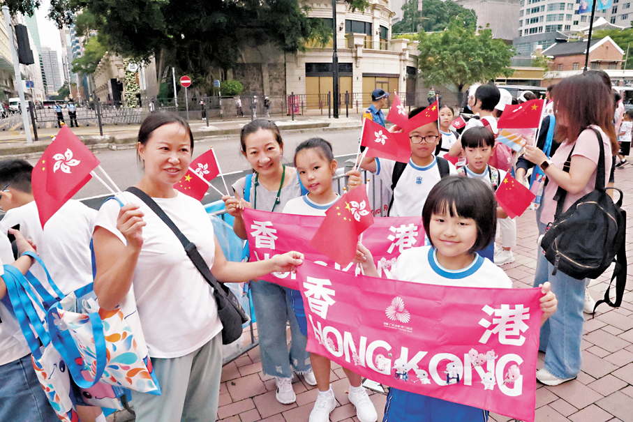 ●尖沙咀現場助威聲此起彼伏，亦不乏稚嫩童聲，學生身穿校服、手持國旗，是「加油軍」的主力之一。 香港文匯報記者萬霜靈  攝