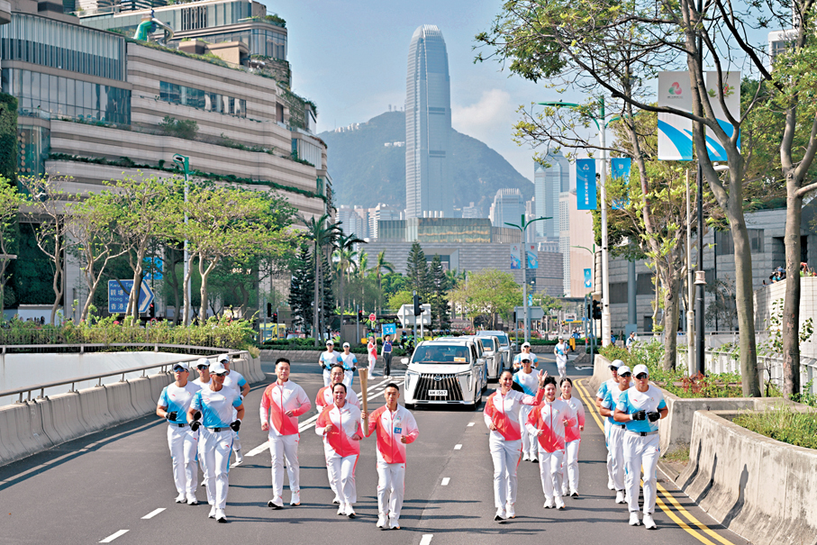 ●香港著名騎師何澤堯（左四）與助跑火炬手何宇軒（左一）、羅達明（左二）、Amanda Bond（左三）、Hanane Sabri（左五）、黎彥麟（左六）和何嘉楠（左七），在梳士巴利道傳遞聖火（只計紅衣者）。