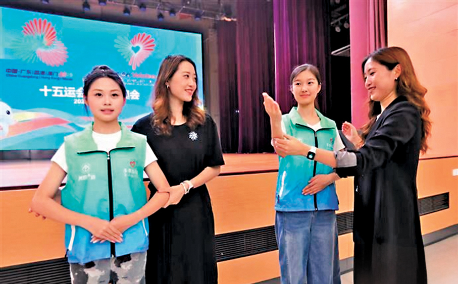 ●吳怡（右一）為志願者示範標準站姿。 網上圖片