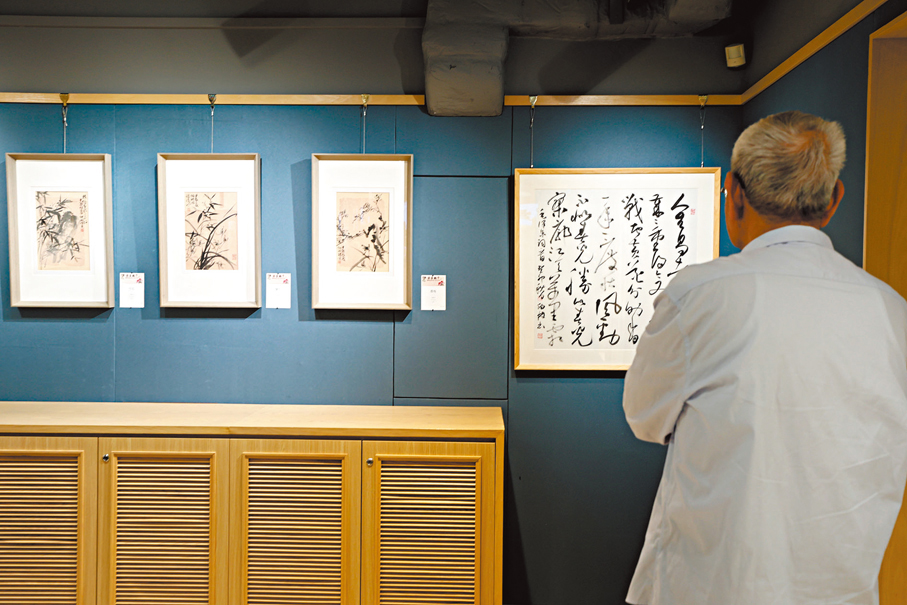 ●觀眾現場欣賞周伯林書畫作品。