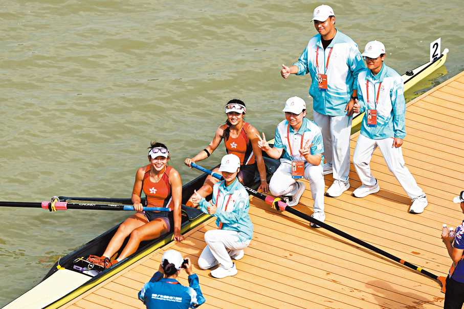 ●梁瓊允（左）/黃湘儀賽後與志願者合影留念。 新華社