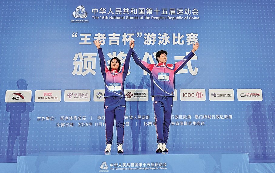 ●覃海洋（右）與教練在頒獎儀式上。  新華社