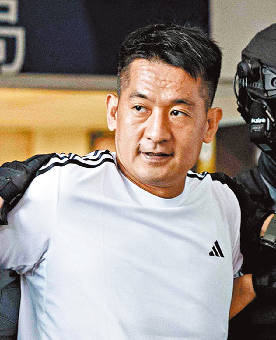 ●泰國警方12日押送佘智江離開警察局，隨後將他移交給中國。 法新社