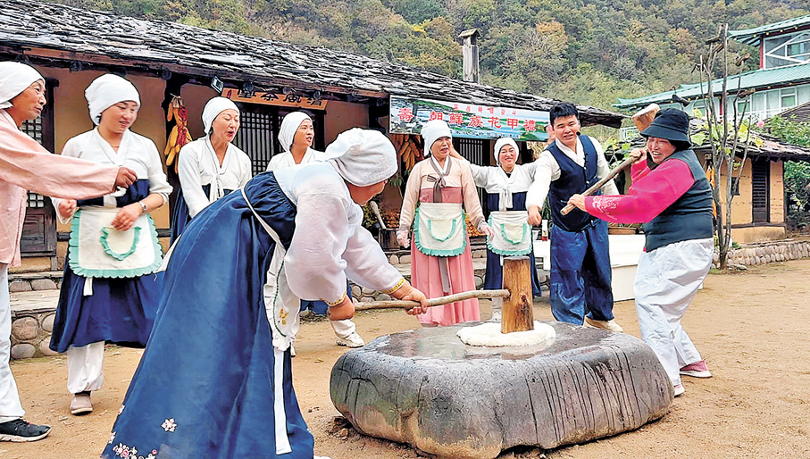 ●三道河朝鮮族民俗村內的朝鮮族女性載歌載舞展示製作傳統打糕場景。