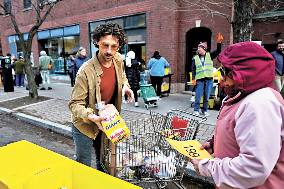 ●義工在芝加哥一個食物捐贈中心協助民眾領取食物。 美聯社