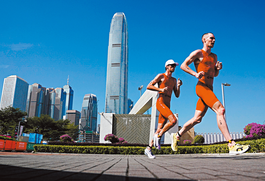 ●11月15日，香港隊選手奧斯卡（右）在鐵人三項跑步比賽中。 新華社