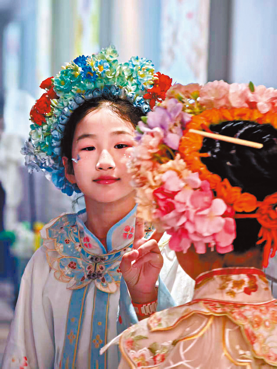 ●在泉州街頭上，穿戴簪花拍照的女孩們。 香港文匯報記者李薇  攝