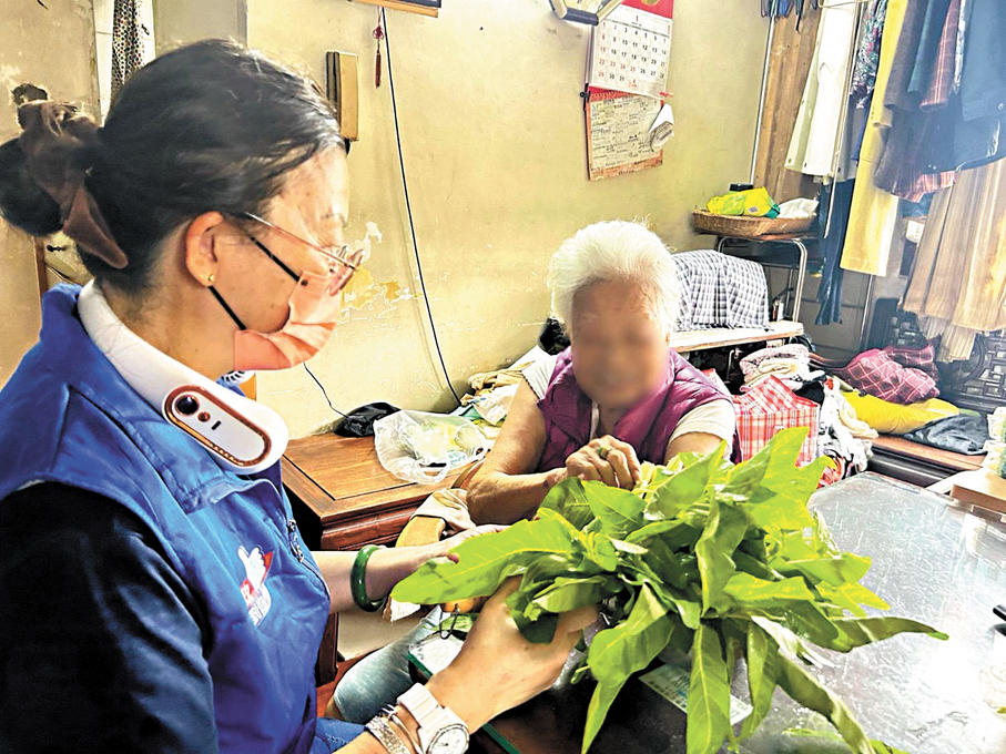●關愛隊將蔬菜贈予獨居婆婆，並向她介紹有機耕種的過程。 作者供圖