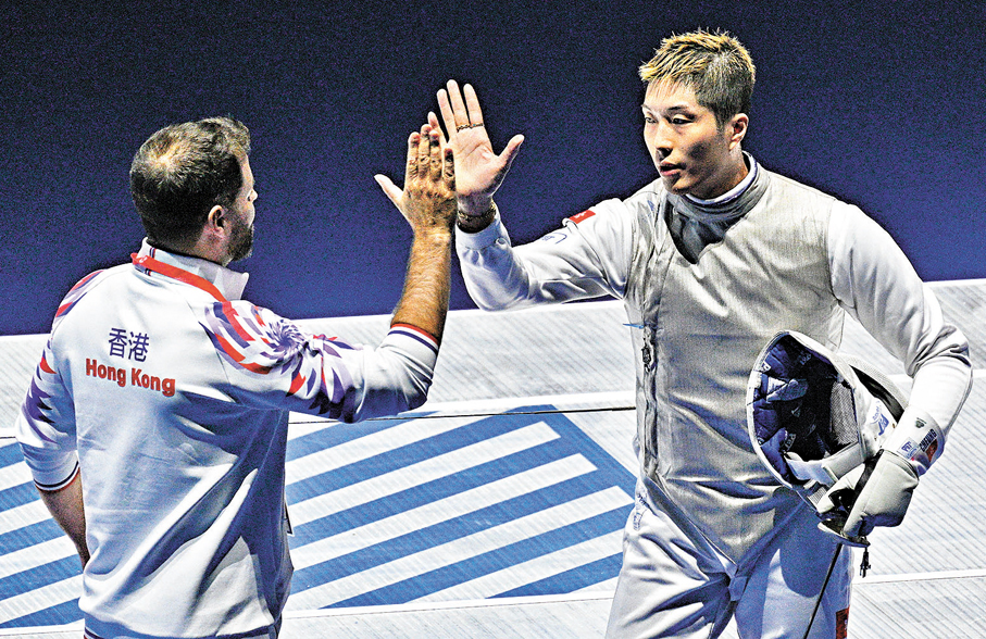 ●張家朗（右）賽後與教練擊掌慶祝。 新華社