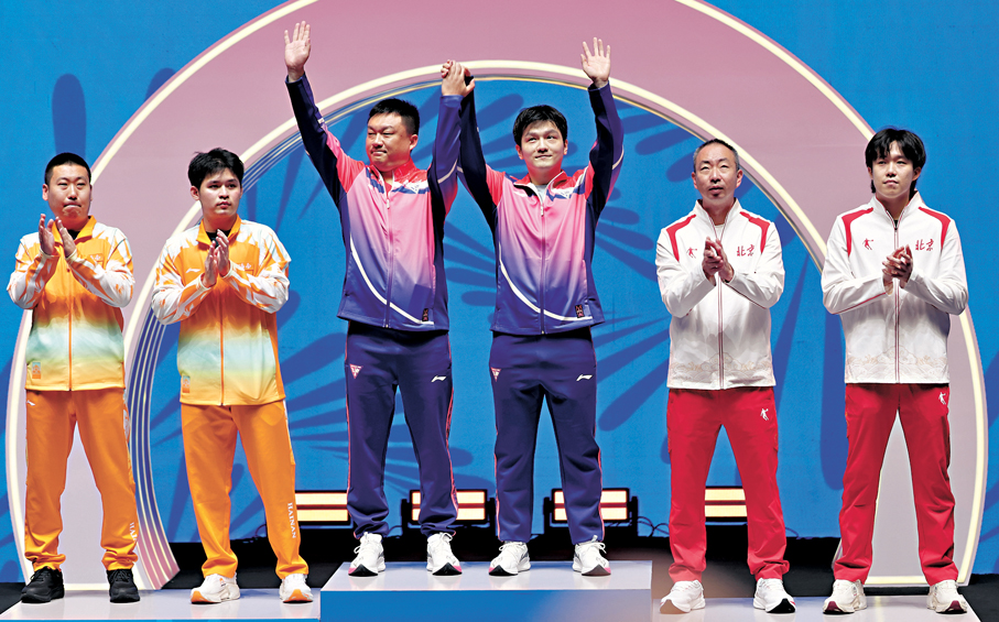 ●樊振東（右三）、林詩棟（左二）、王楚欽（右一）和他們的教練員在頒獎儀式上。  新華社