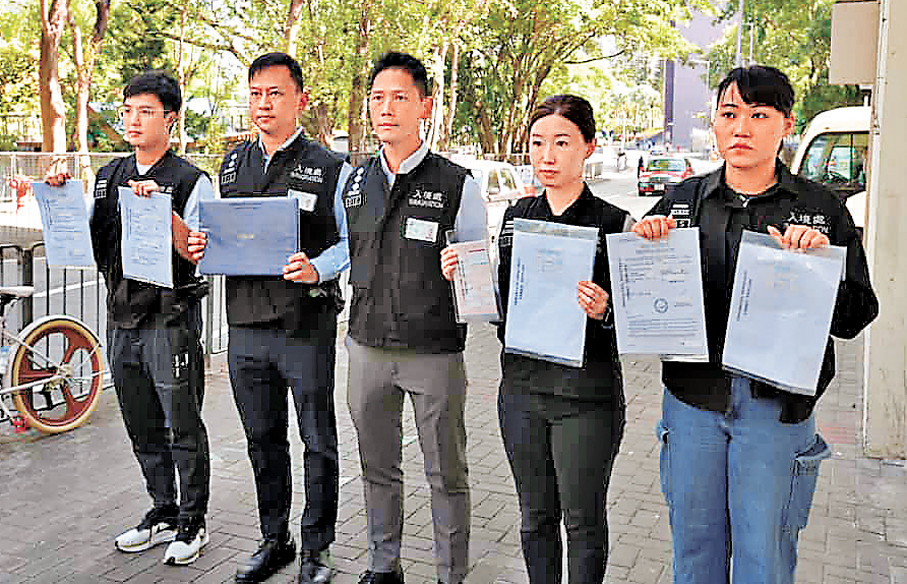 ●入境處人員展示於行動中檢獲結婚證明文件及身份證副本等證物。