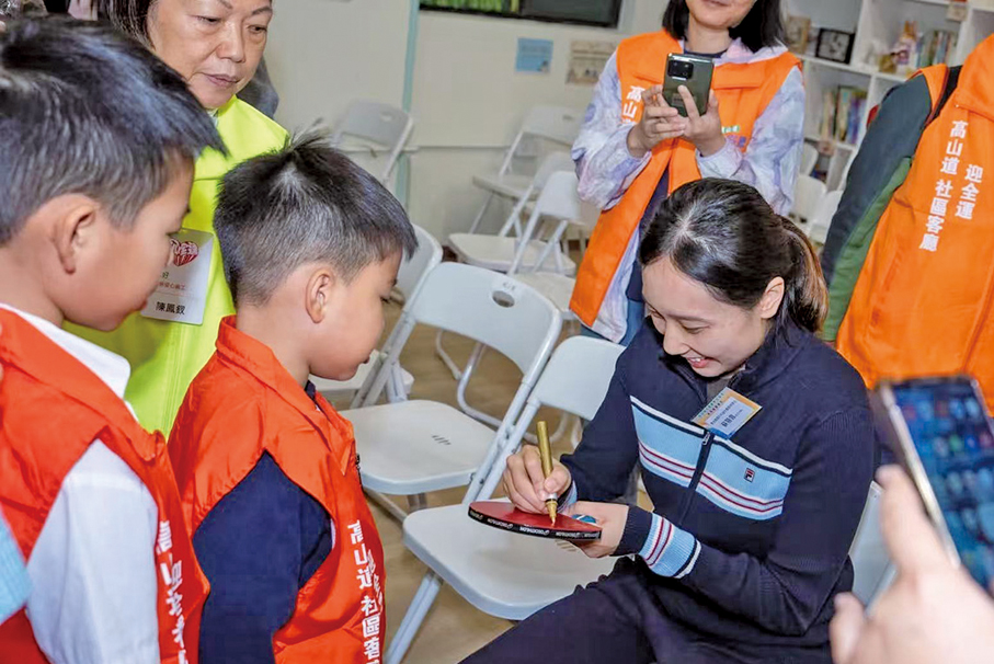 ●蘇慧音在乒乓球拍上簽名，送給社區客廳劏房戶小球迷作紀念。