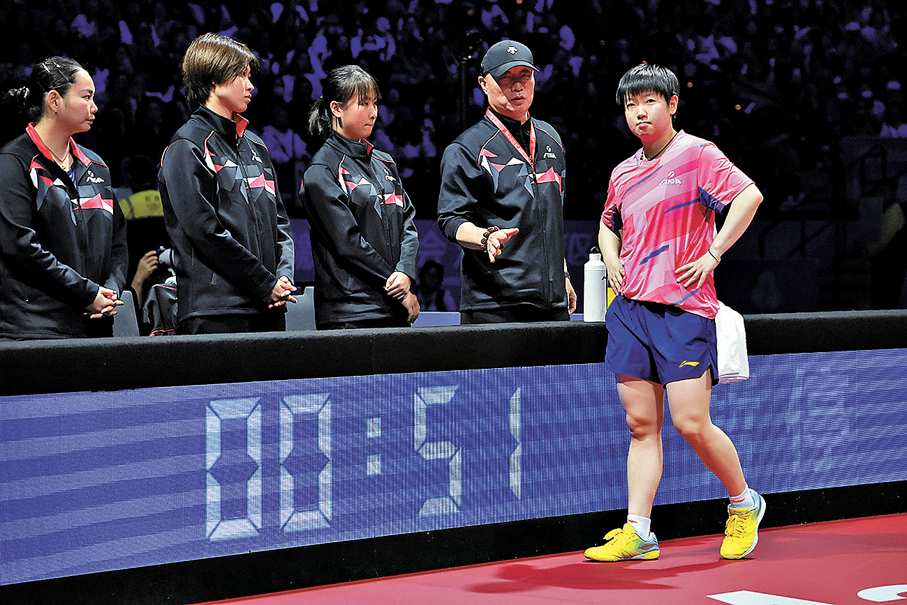 ●孫穎莎（右一）在女單比賽中與團隊交流。  新華社