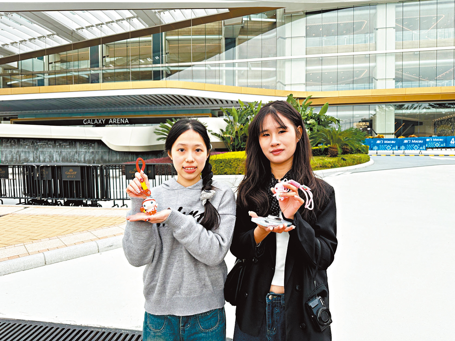 ●來自佛山的陳小姐與吳小姐展示購買的吉祥物周邊產品。  香港文匯報記者王思佳  攝