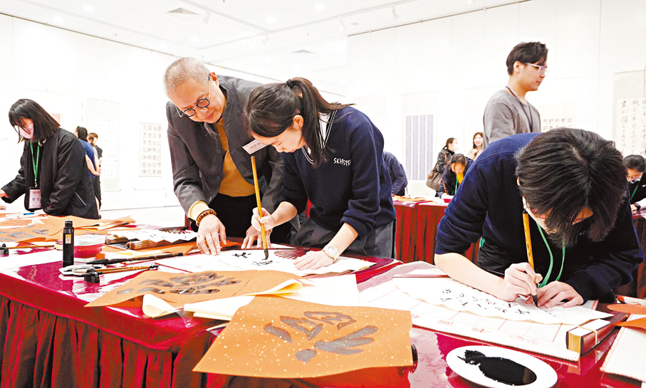 ● 主辦方特別設置「筆會」環節，邀請書法名家現場「大手牽小手」指導獲獎同學，即席書寫抗戰詩詞名言，又於扇面上創作「投入選舉，共創未來」，呼籲各界踴躍投票。香港文匯報記者曾興偉  攝