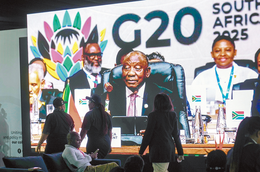 ●南非總統拉馬福薩宣布G20峰會閉幕。人們走過大電視。 美聯社
