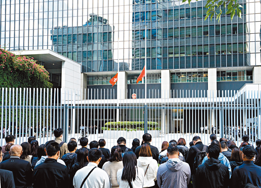 ●部分香港民眾在特區政府總部前肅立，向大埔宏福苑火災罹難者表達哀思。 中新社