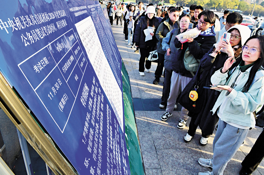 ●11月30日，中央機關及其直屬機構2026年度考試錄用公務員公共科目筆試在全國各考區統一舉行。圖為30日，在江蘇無錫旅遊商貿高等職業技術學校考點，考生在查看考場信息。 新華社