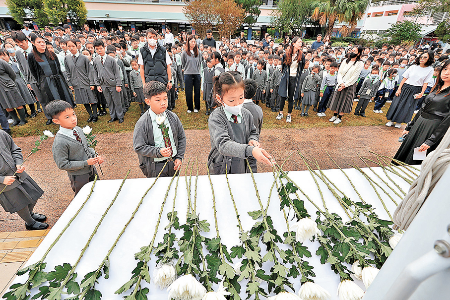 ●各班學生代表、校長及教職員逐一上台獻花。 香港文匯報記者黃艾力  攝