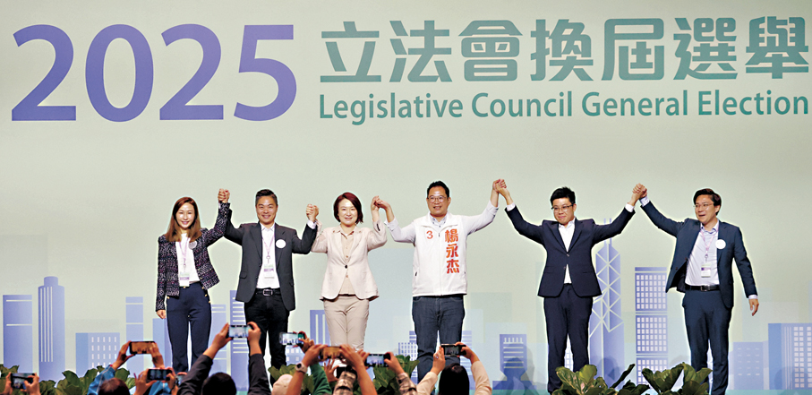 ●九龍中候選人同台手牽手。 香港文匯報記者曾興偉  攝