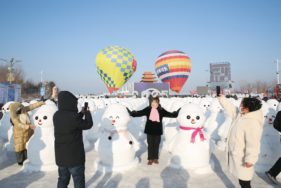 ●每到冰雪季，各色雪雕、冰雕吸引遊客打卡留念。圖為遊客與雪人造型的雪雕矩陣合影。  陳鴻博 攝