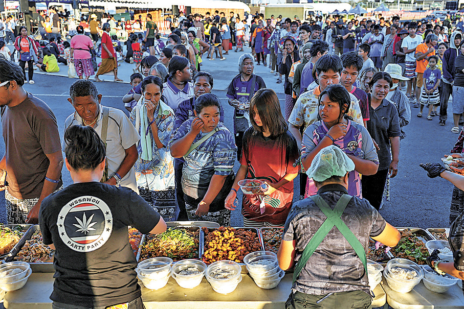 ●泰國流離失所民眾在臨時避難所排隊領取食物。 路透社
