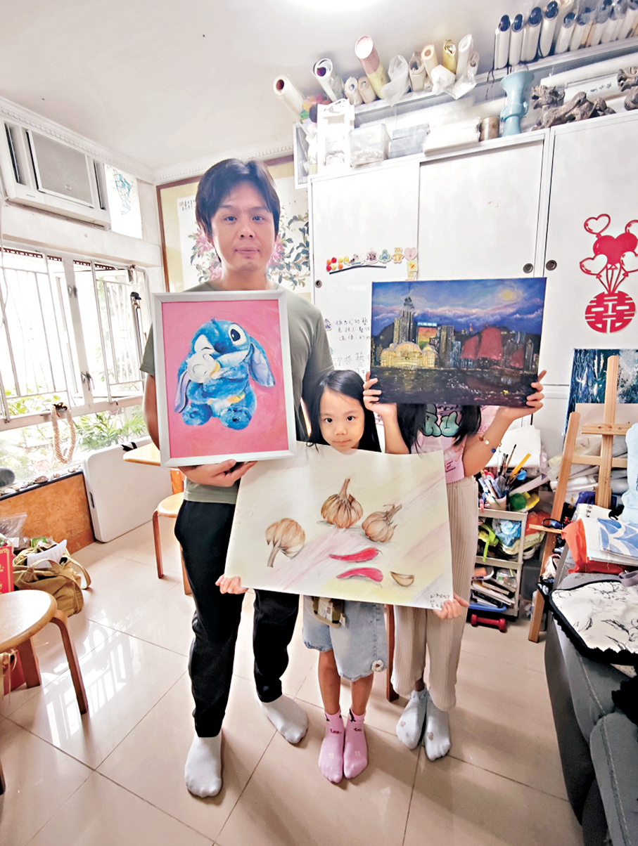 ●莫鈞陶與兩個女兒展示自己的畫作。