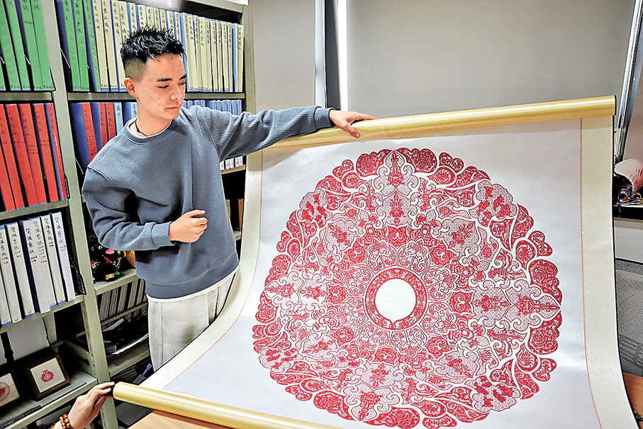 ●賀強展示其剪紙作品。 中新社