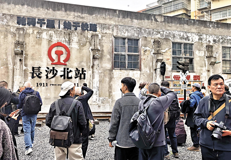 ●長沙市東風路文創園迎面一堵舊廠房牆上，「長沙北站」4個大字引人注目。遊客們在長沙北站的站牌下拍照打卡。香港文匯報長沙傳真