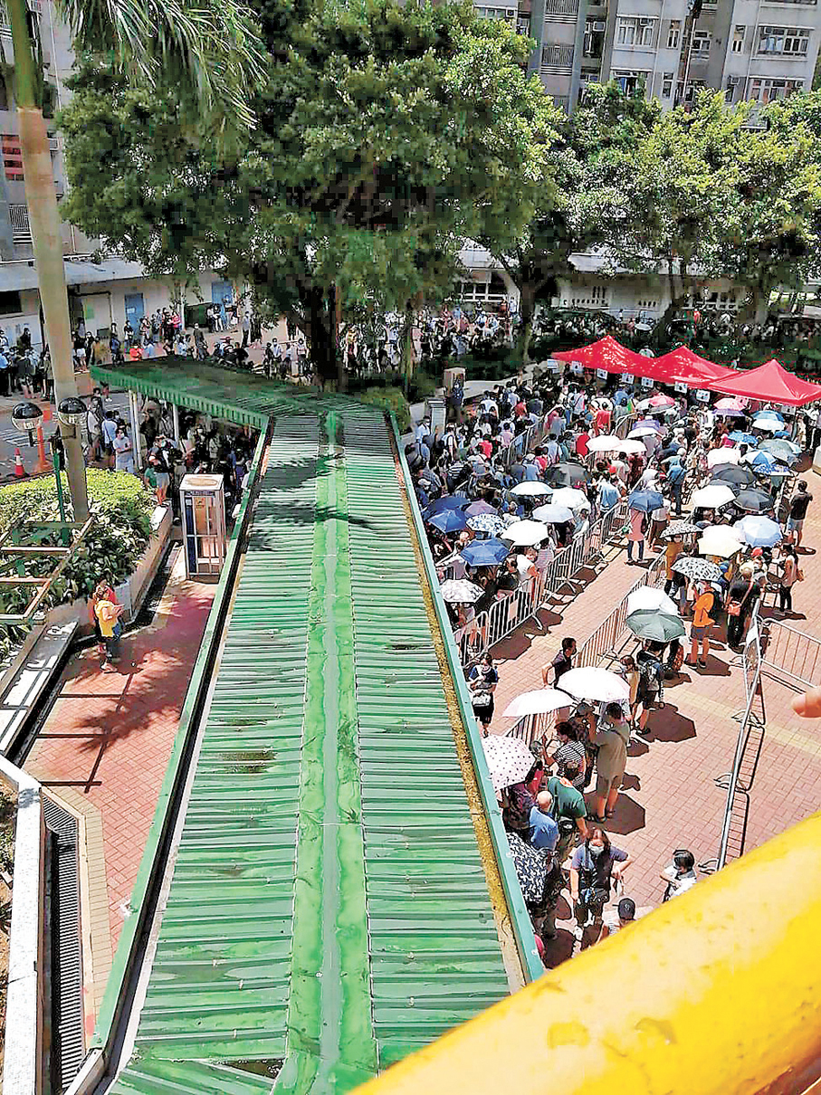 小業主冒着烈日排長龍，就是為了前往大會反對法團提議。 受訪者提供