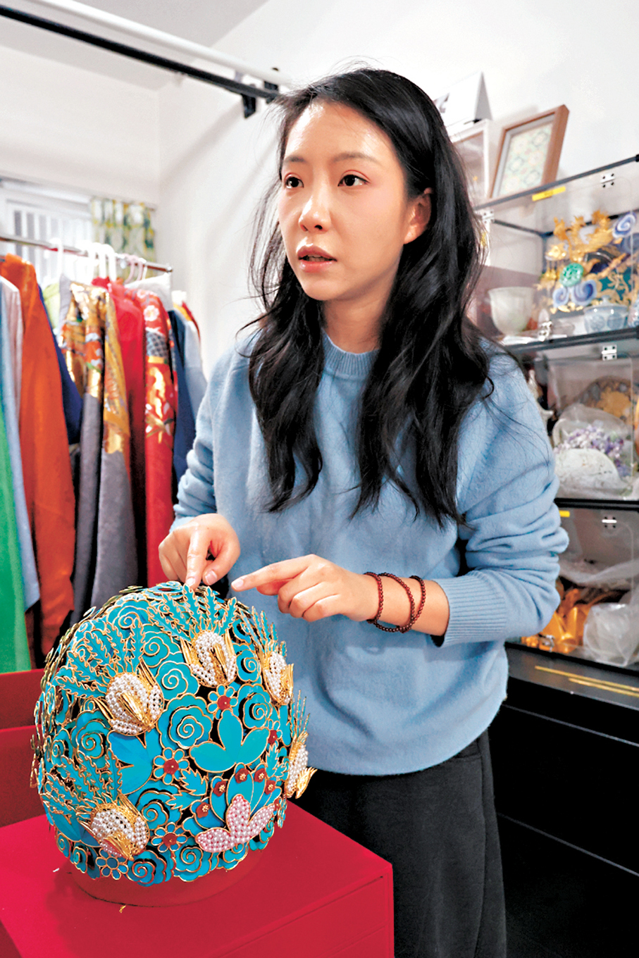 ●劉揚介紹商品冠—明華堂五翟冠，可以搭配額帕戴在頭上。香港文匯報記者  黃艾力  攝