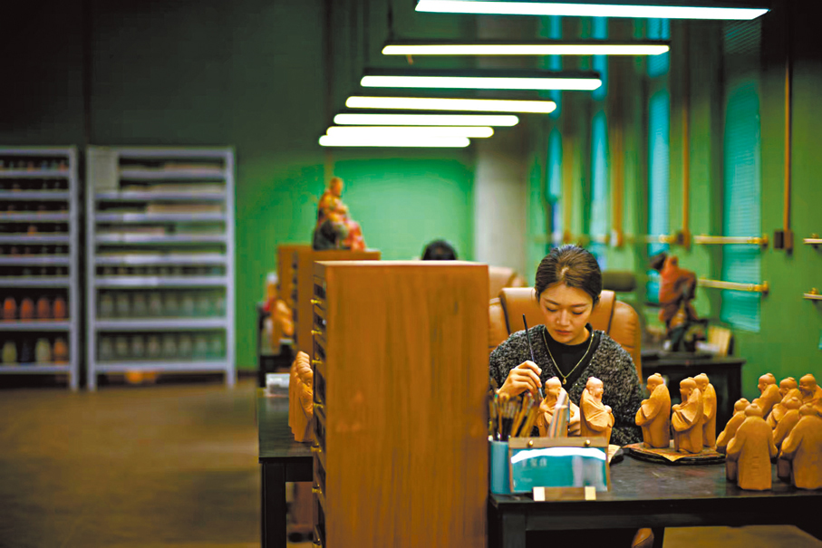 ●在天津市泥人張世家繪塑老作坊3樓彩繪部，一名工藝美術師對泥塑坯體進行彩繪。 中新社