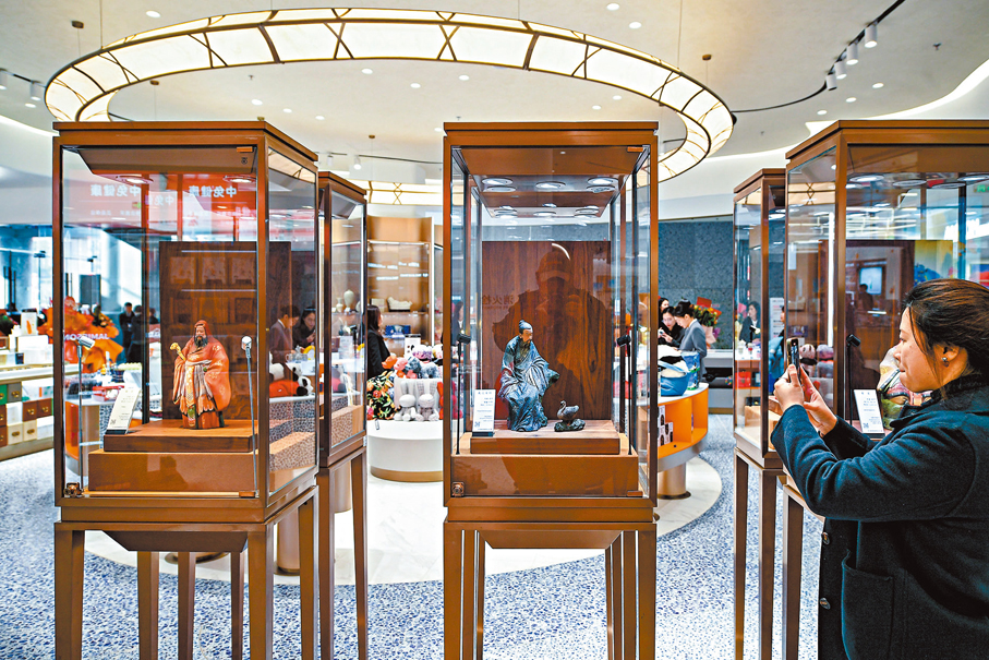 ●顧客在「泥人張」彩塑展示櫃前打卡拍照。 中新社