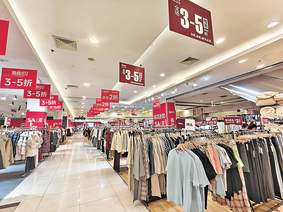 ●商場裏貼滿打折促銷海報。  香港文匯報記者任芳頡  攝