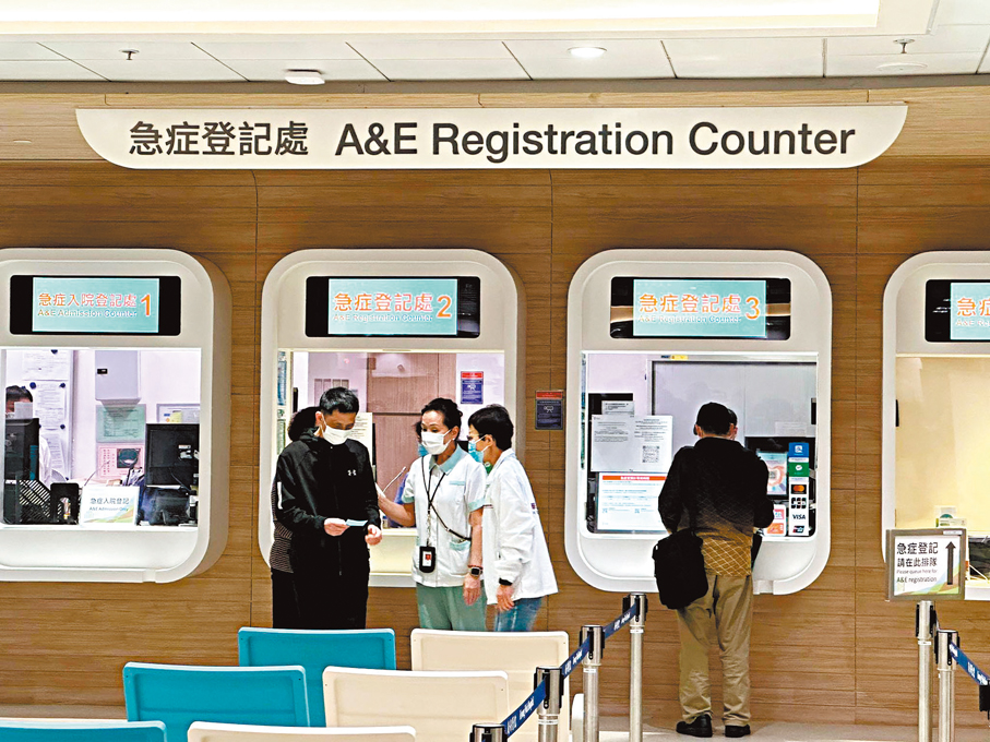 ●廣華醫院急症室的人員在踏入零時前，已向求診人士講解新收費內容。 香港文匯報記者李千尋  攝