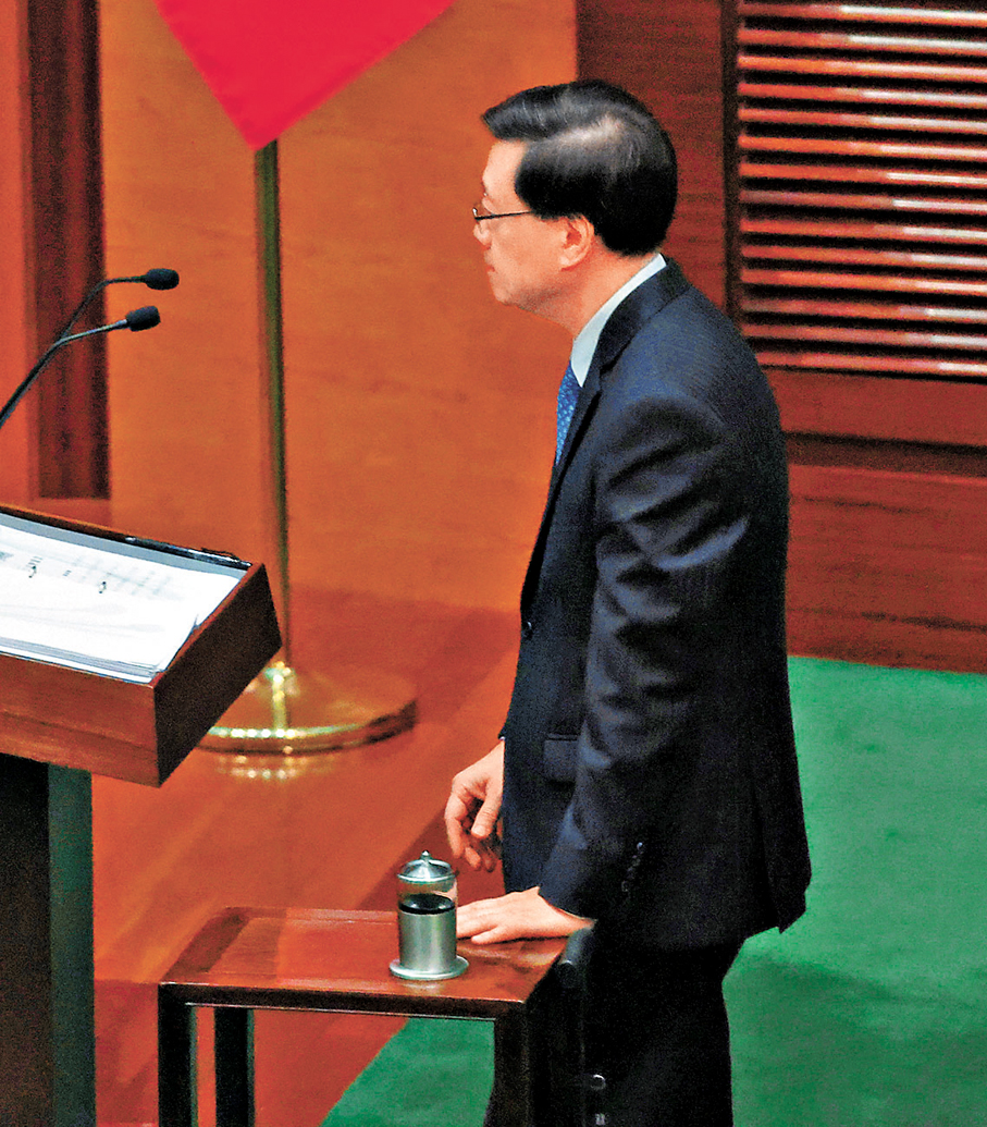 ●李家超用茶几支撐身體監誓。香港文匯報記者郭木又  攝