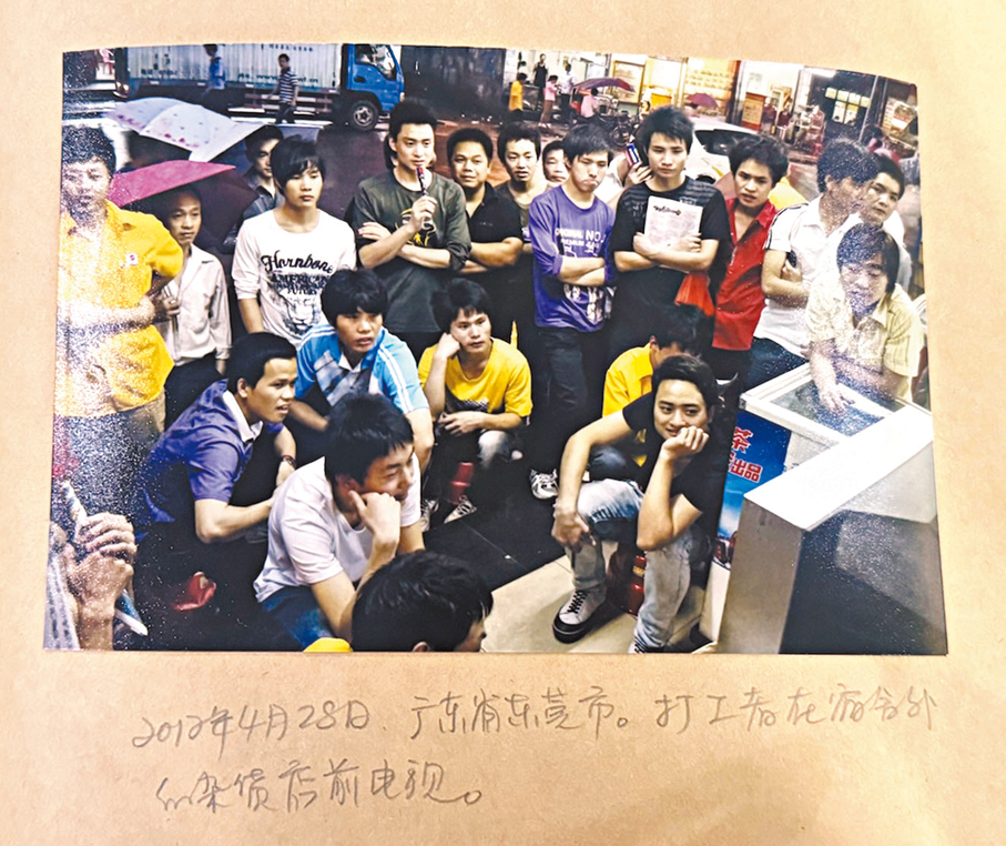 ●二○一二年，打工人在雜貨店前看電視。