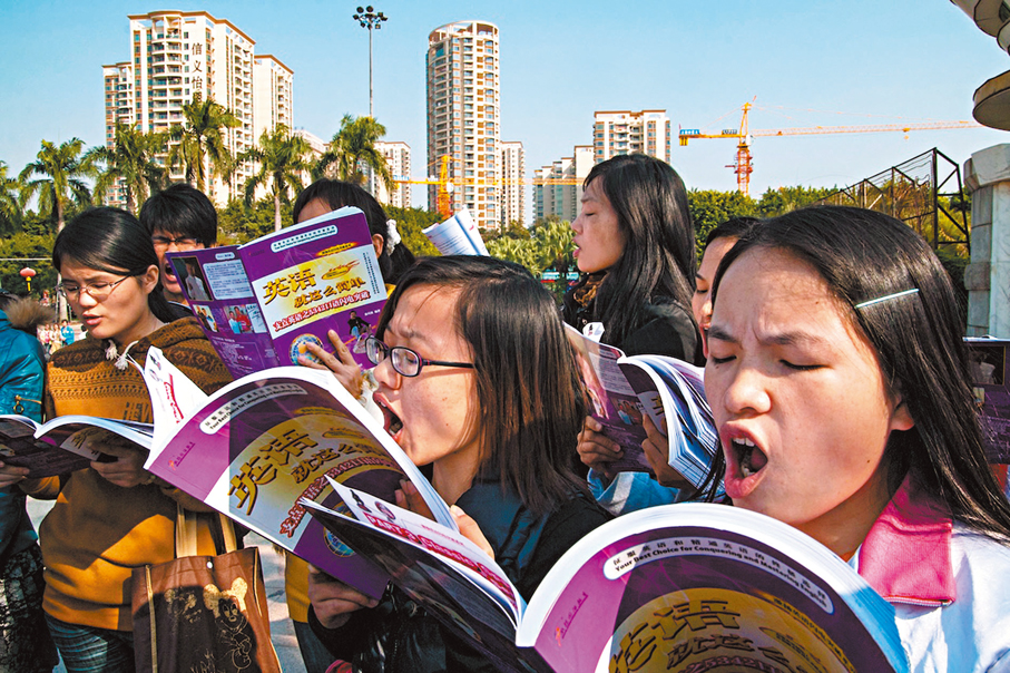 ●2011年1月1日，東莞。打工人跟着培訓老師在廣場讀英語。