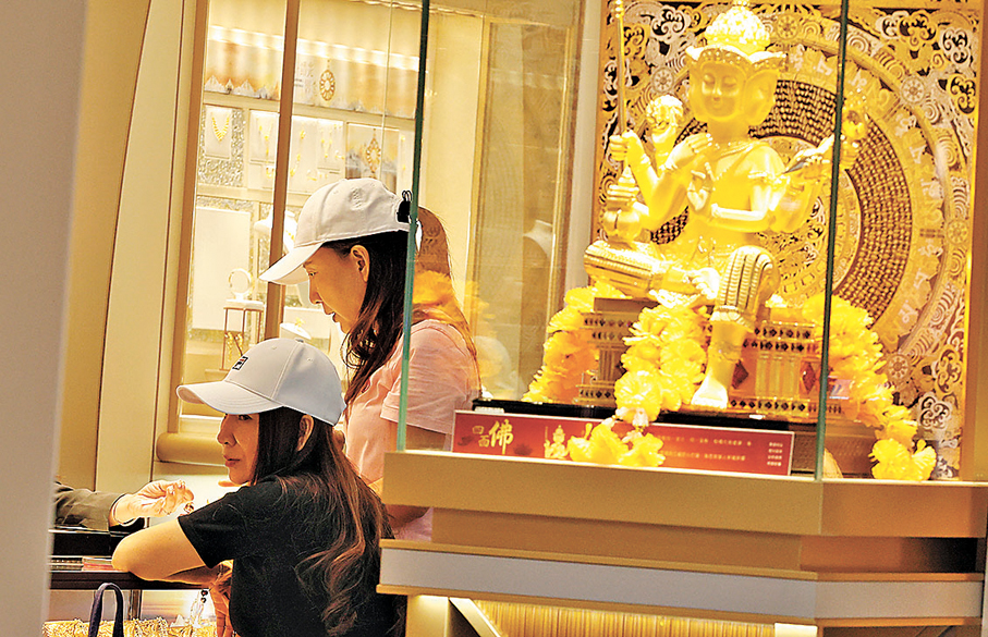 ● 金價升勢凌厲，反促使消費者在購買黃金產品時更重視其投資價值，並帶動了金飾金器銷售。圖為顧客在選購金器。 資料圖片