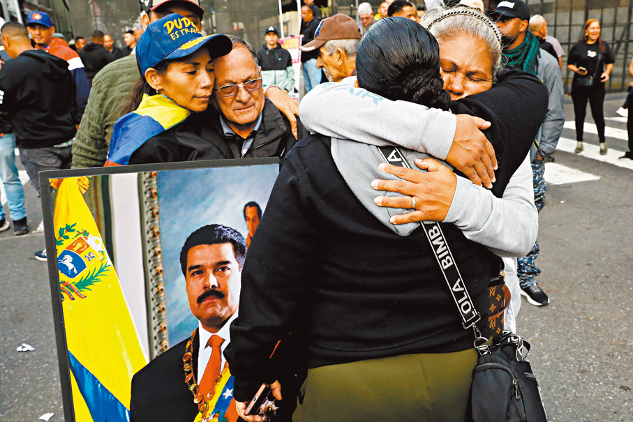 ●特朗普宣布美軍抓獲馬杜羅後，馬杜羅支持者在委內瑞拉首都加拉加斯市中心擁抱安慰。美聯社