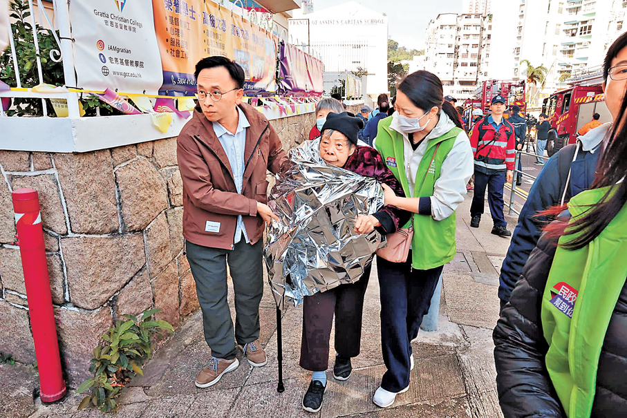 ●有疏散到樓下的長者要披上錫紙保暖。 香港文匯報記者劉友光  攝