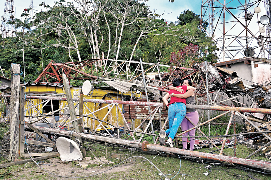 ●委內瑞拉居民在廢墟旁與親人擁抱。 路透社