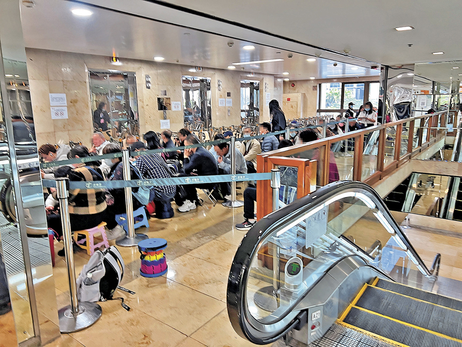 ●中午12時半，排隊黨帶備凳子，擠滿電梯大堂。香港文匯報記者廣濟 攝