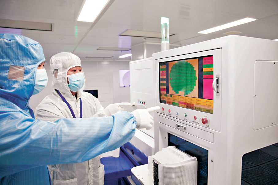 ●陜西日月芯半導體有限公司董事長鄧勝斌（左）在芯片生產車間查看生產情況。 香港文匯報記者李陽波  攝